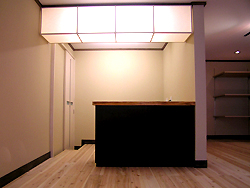 杉板で作ったレジカウンターです。 上には、和紙を貼った手作りの照明器具を天井につけました。 柔らかい光がいいですよね。